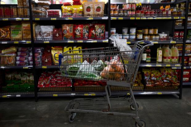 A shopping cart filled with groceries sits in an aisle at an Asian grocery store in Rowland Heights, Calif.